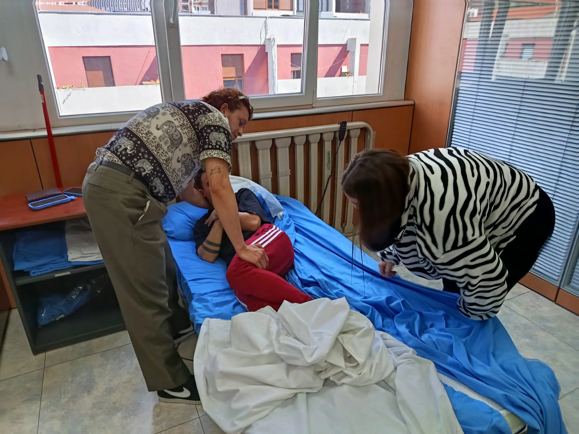 Práctica guiada de cambios posturales y movilización de una persona en cama durante una formación de Eune