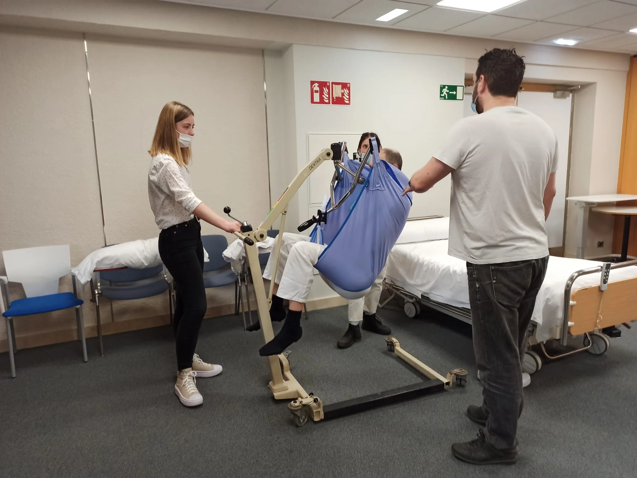 Práctica de transferencia con grúa y arnés durante un curso de movilización de personas dependientes