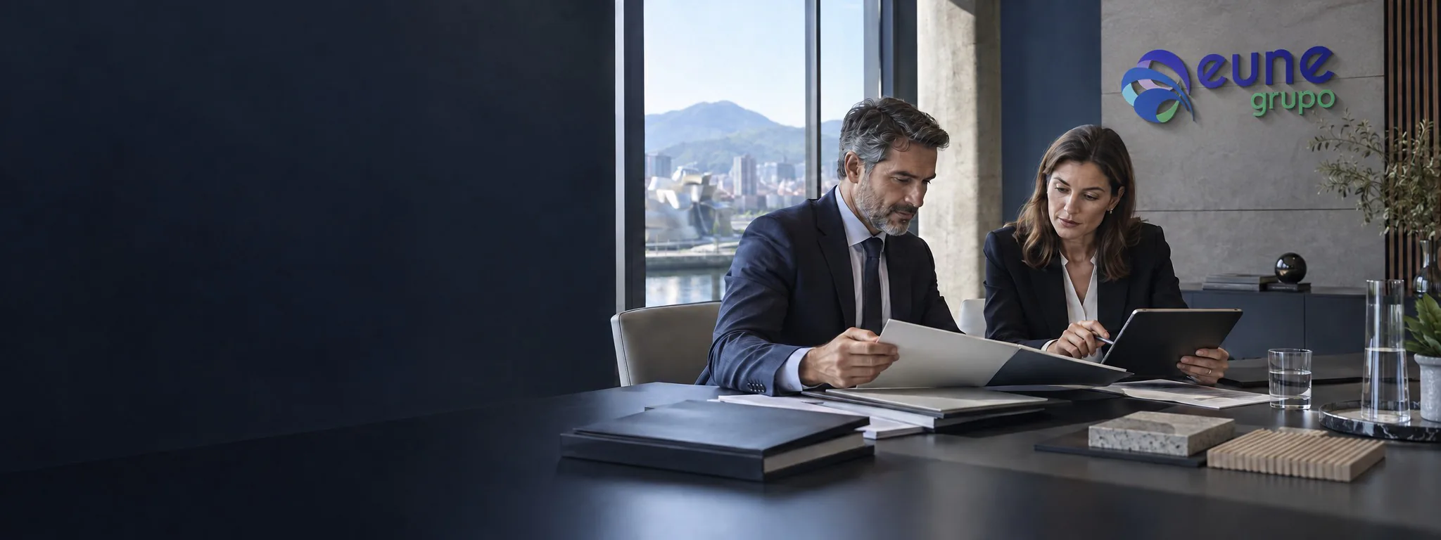 Profesionales de Eune revisan documentación técnica en un espacio corporativo con el logotipo del grupo